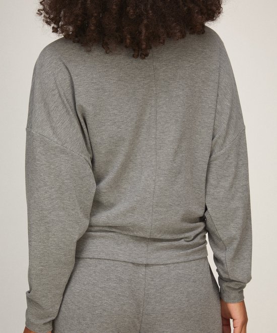 Achterzijde van model in grijze loungewear top met vleermuismouwen.