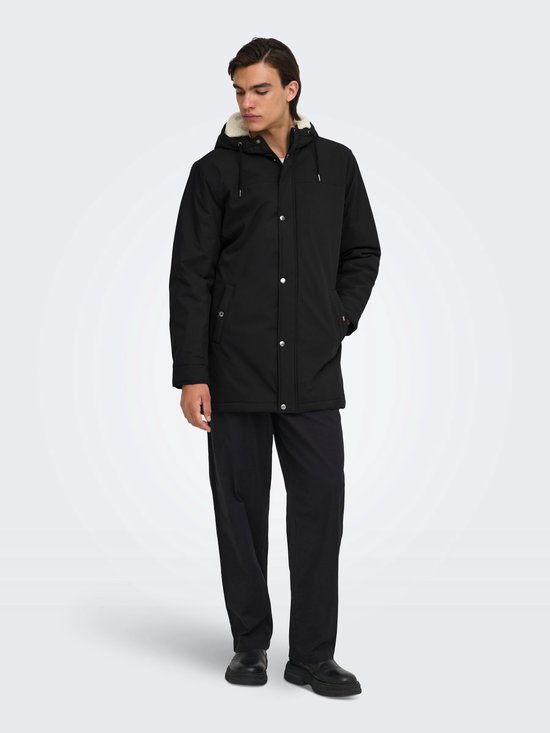 Zwarte parka met capuchon en crèmekleurige voering, gedragen door een model.