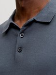Detail van de donkerblauwe gebreide poloshirt met knopen.