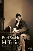 Patti Smith M Train Erinnerungen. Zittend aan tafel met een typemachine en kopje.