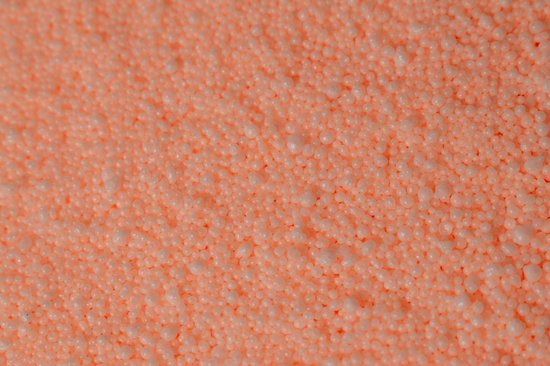 Close-up van licht oranje kaarsenzand met kleine parels.