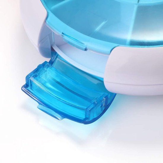 Close-up van de helderblauwe, transparante dispenser van een ronde, witte pillendoos.
