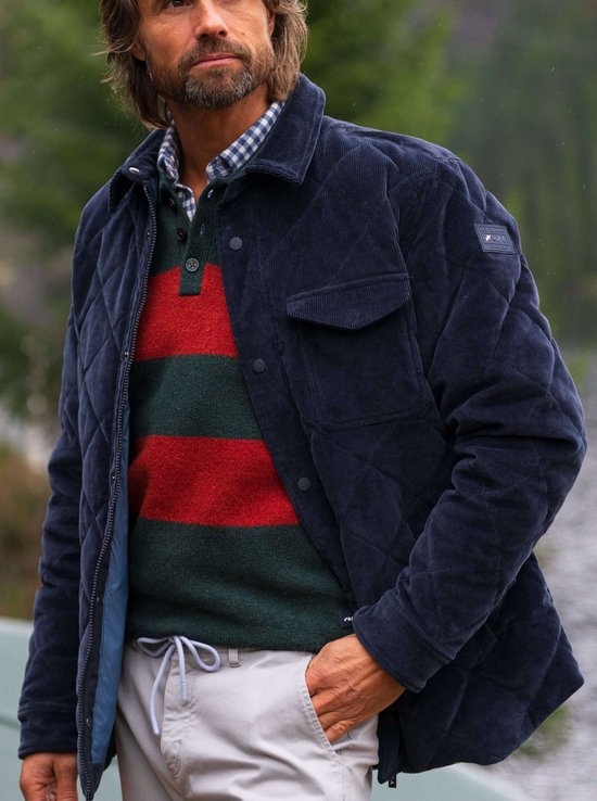 Model draagt een donkerblauw gewatteerd corduroy N.Z.A. jack over een rood-groene gestreepte trui.