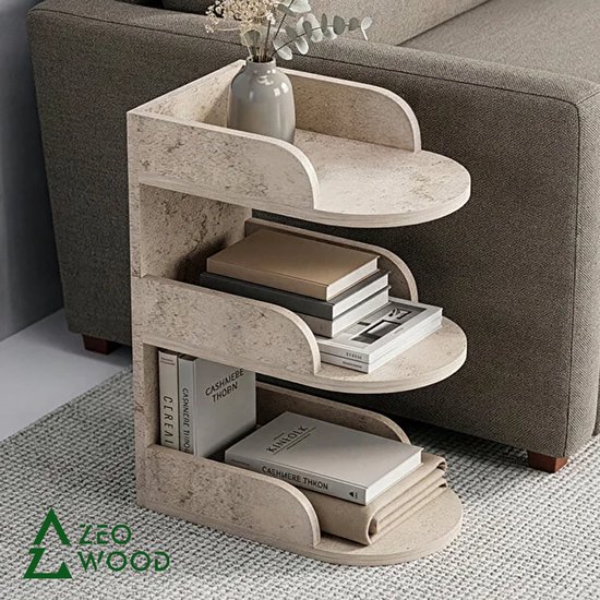 Moderne beige Zeo Wood bijzettafel met marmerpatroon, drie open schappen gevuld met boeken, naast een grijze bank.
