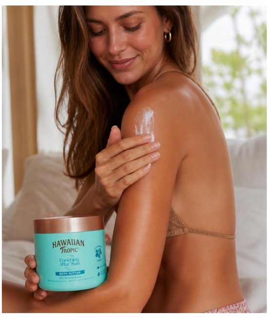 Vrouw brengt Hawaiian Tropic Enriching After Sun bodybutter aan op haar schouder, turquoise pot met koperen deksel.