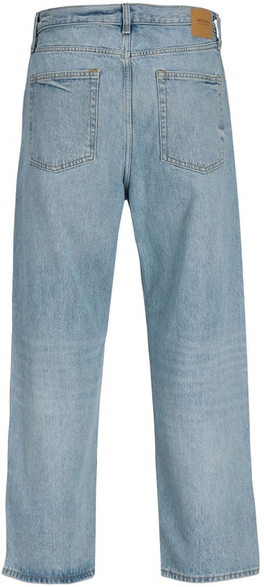 Achterkant van een lichtblauwe baggy jeans met twee achterzakken en een bruin leren merklabel.