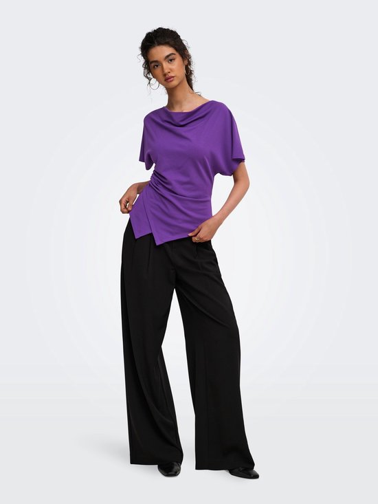 Model draagt een paarse ONLY top met gedrapeerde hals en asymmetrische zoom, gecombineerd met zwarte wijde broek.