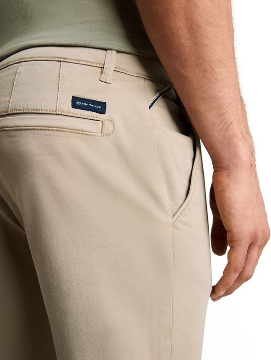 Beige chino broek met 'Tom Tailor' logo op de achterzak. De broek heeft een casual, gewassen look.