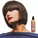 Vrouw met een bruin bobkapsel en rode lippen naast een fles Reuzel Spray Grooming Tonic.