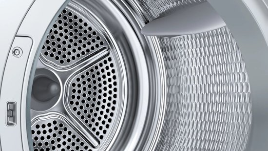 Close-up van de metalen trommel van een Siemens wasdroger met perforaties en honingraatstructuur.