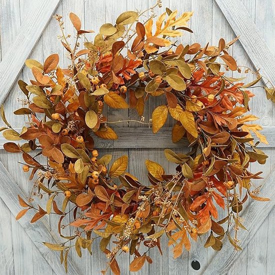 Herfstkrans met bladeren in oranje, bruin en geel, versierd met kleine oranje besjes.