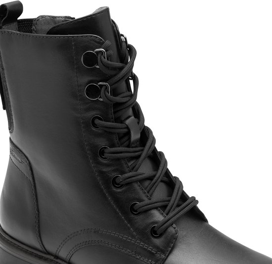 Detail van de voorkant van een zwarte leren veterlaars met veters en oogjes.