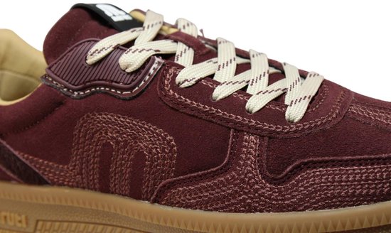Bordeauxrode suède sneaker met beige veters, geborduurde details en een beige rubberen zool.