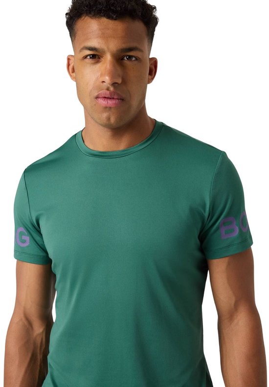 Man in groen sportshirt met paarse tekst op de mouw.