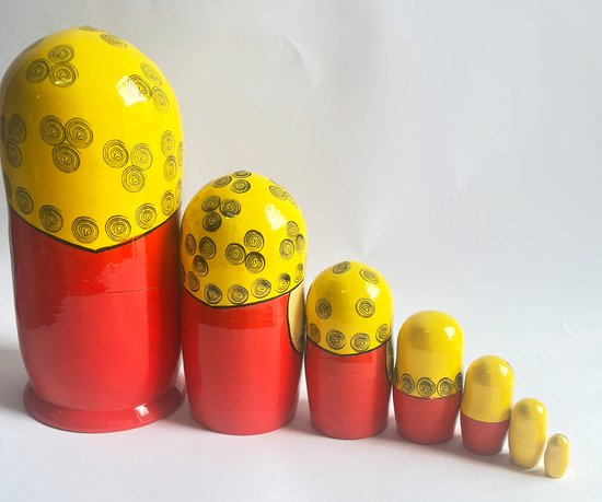 Zeven Matroesjka poppen, oplopend in grootte, met gele bovenkanten met zwarte cirkels en rode onderkanten.
