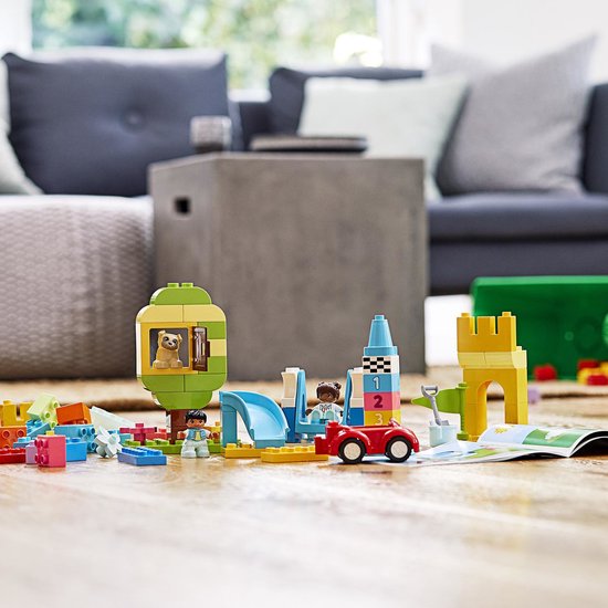 Jouets LEGO DUPLO avec une cabane dans l'arbre, un toboggan, une voiture rouge, deux figurines et un paresseux.