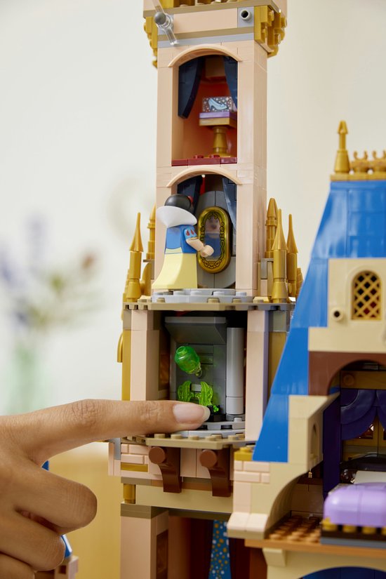 Een close-up van het LEGO Disney Kasteel, Sneeuwwitje kijkt in een spiegel, een groene figuur zichtbaar.