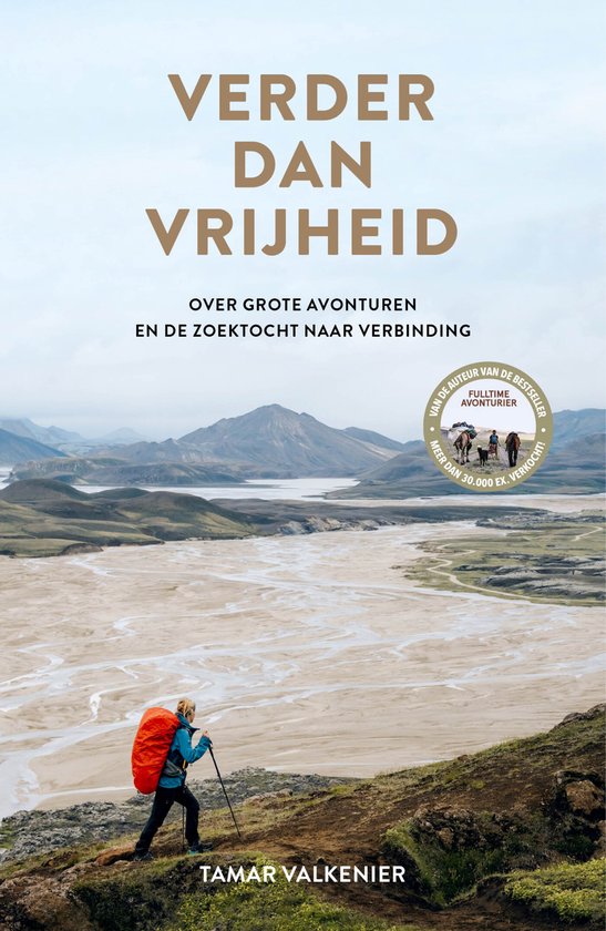 Boekomslag met de titel 'Verder dan vrijheid' en een vrouw met oranje rugzak die op een heuvel staat met uitzicht op een brede, droge rivierbedding.