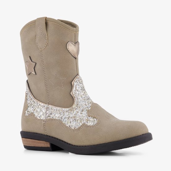 Driekwart aanzicht van een beige cowboylaars met glitters, ster en hartvormige versiering.