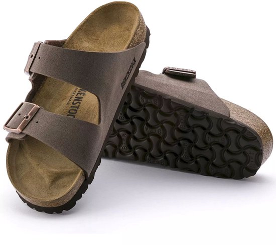Bruine Birkenstock Arizona sandalen met koperkleurige gespen, kurken zool en op de zool een patroon.
