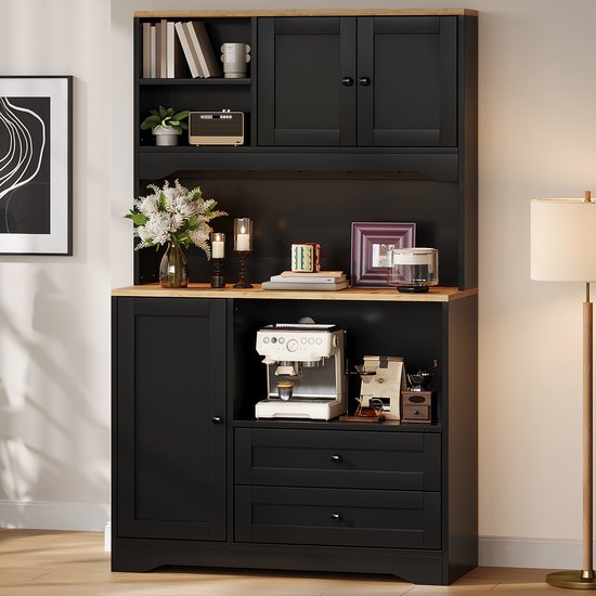 Zwarte buffetkast met houten blad, decoraties en koffiezetapparaat in een heldere woonkamer.