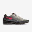 Zijaanzicht van grijze mesh sneaker met opvallende roze Nike swoosh en zwarte Air Max zool.