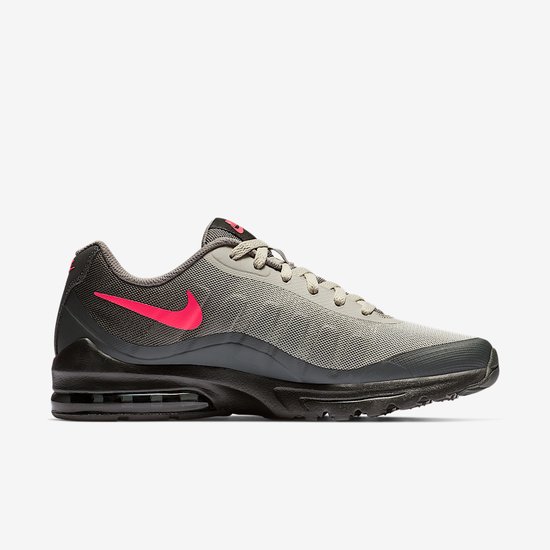 Zijaanzicht van grijze mesh sneaker met opvallende roze Nike swoosh en zwarte Air Max zool.