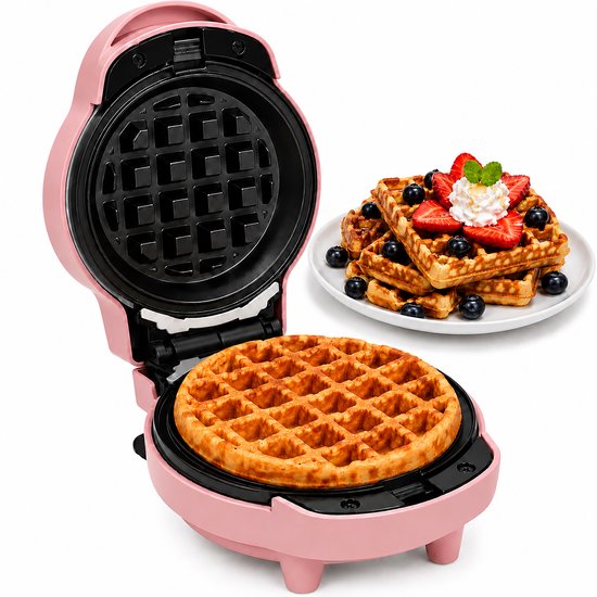 Roze mini wafelijzer met open klep en een bord met verse wafels met aardbeien en blauwe bessen.
