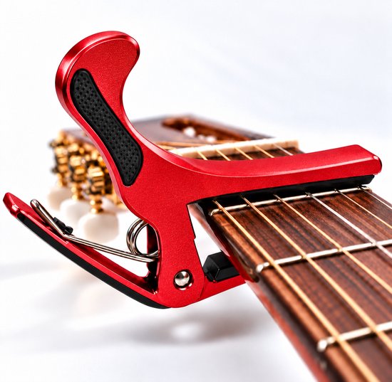 Rode gitaarcapo bevestigd aan de hals van een akoestische gitaar.
