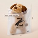 Bruine hondenkuffel slaapt in plastic verpakking met "ZoëZo Design" logo.