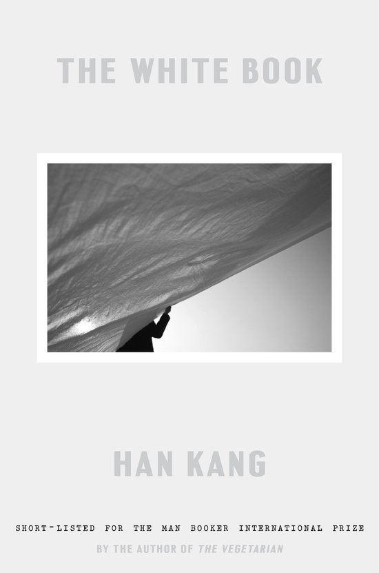 Boek "The White Book" door Han Kang. Een persoon houdt een wit doek omhoog.