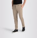 Man in beige chino broek met zwarte sneakers en zwarte T-shirt, handen in zakken.