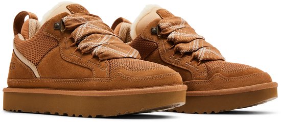 Paar bruine UGG sneakers met suède, mesh, bont gevoerde kraag en brede, gevlochten veters.