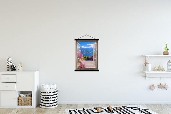 Une affiche textile avec porte-affiche est accrochée au mur au-dessus d'une commode blanche et de jouets.