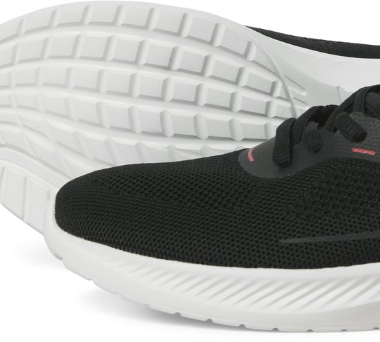 Zwarte sneaker met witte zool. De zool heeft een noppenprofiel. Detail van de neus.