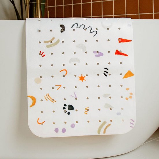 Tapis de bain antidérapant blanc avec motifs colorés, accroché au bord d'une baignoire blanche.