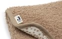Detail van bruin, teddy-achtig verschoningsmatje met beige rand en Jollein-label. Beige stippen zichtbaar aan binnenkant.