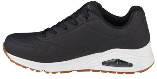 Zwarte Skechers Uno dames sneaker met witte zool en bruin accent op de zool.