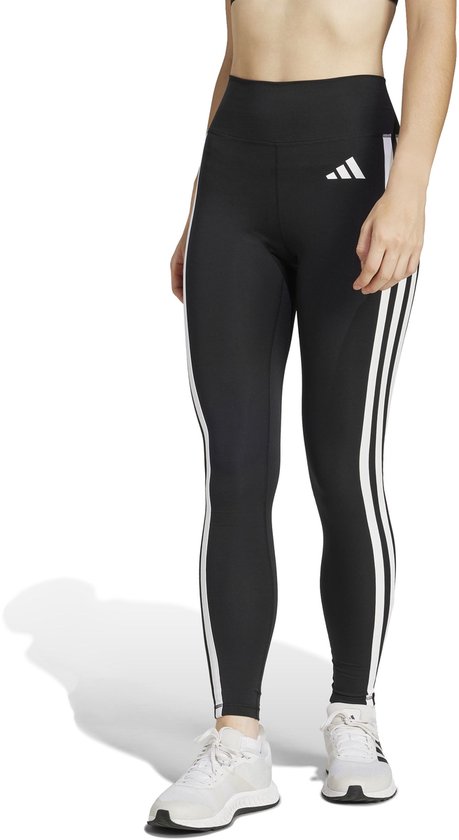 Vrouw in zwarte sportlegging met witte Adidas strepen op de zijkant en een Adidas logo op de heup.