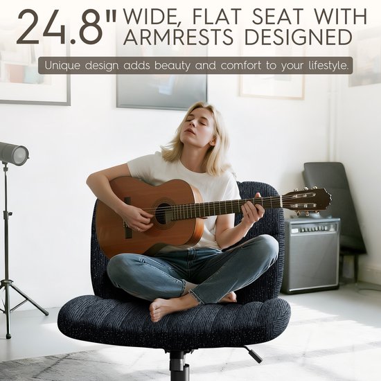 Zwarte bureaustoel met brede zitting van 63cm en armleuningen, gefotografeerd met een vrouw die gitaar speelt.
