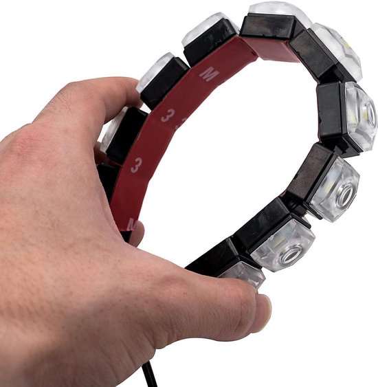 Een hand houdt een zwarte strip met 10 LED-lampjes vast, de rode beschermfolie is deels verwijderd.