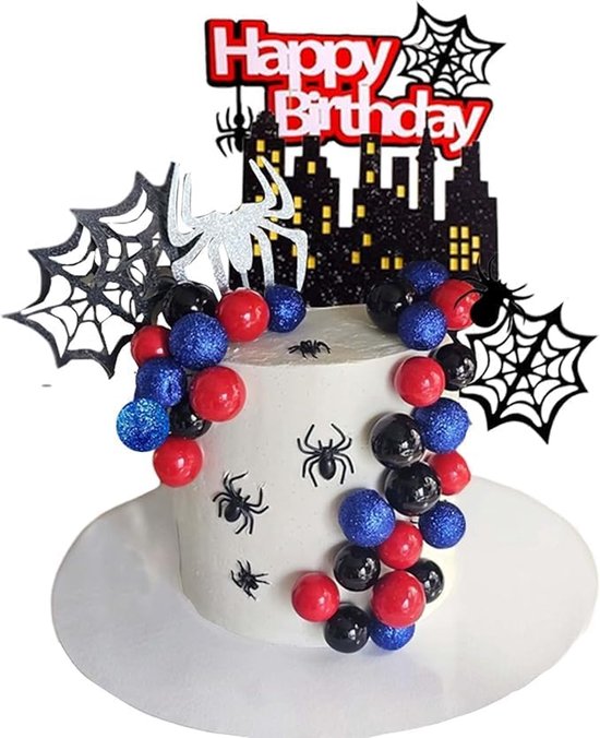 Taartdecoratie met een stadssilhouet, spinnen, webben en rode, zwarte en blauwe ballen. "Happy Birthday"-tekst bovenaan.