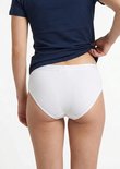 Model draagt de achterkant van een wit hipster broekje van Ten Cate met elastische band.
