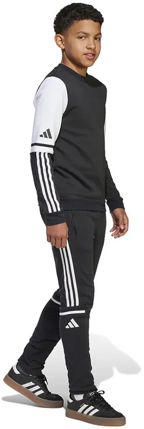 Jongens in een zwarte joggingbroek met witte Adidas-strepen.