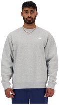 Man met baard draagt een grijze New Balance sweater met een klein wit logo.
