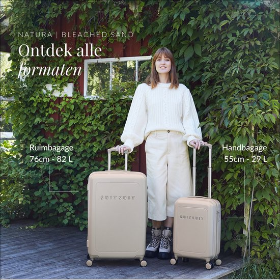 Vrouw in beige kleding met een grote en kleine beige SUITSUIT koffer in de buitenlucht. "Natura Bleached Sand"