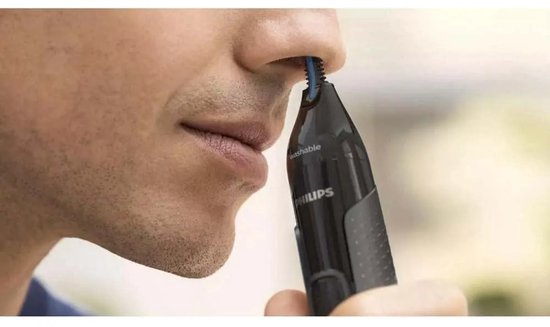 Man trimt neus met zwarte Philips neustrimmer.