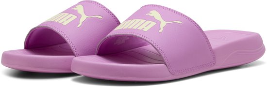 Paar roze Puma slippers met beige Puma logo, gezien vanuit een hoek.