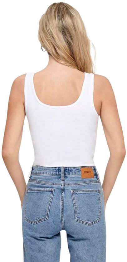 Achterkant van een witte, nauwsluitende tanktop met een ronde hals, gedragen met een spijkerbroek met bruin logo-label.