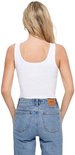 Achterkant van een witte, nauwsluitende tanktop met een ronde hals, gedragen met een spijkerbroek met bruin logo-label.